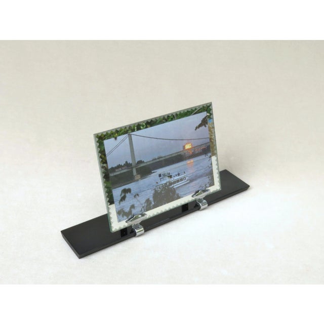 An exceptional picture frame from the Art Deco period from France. An elegant combination of black glass with a chrome-...