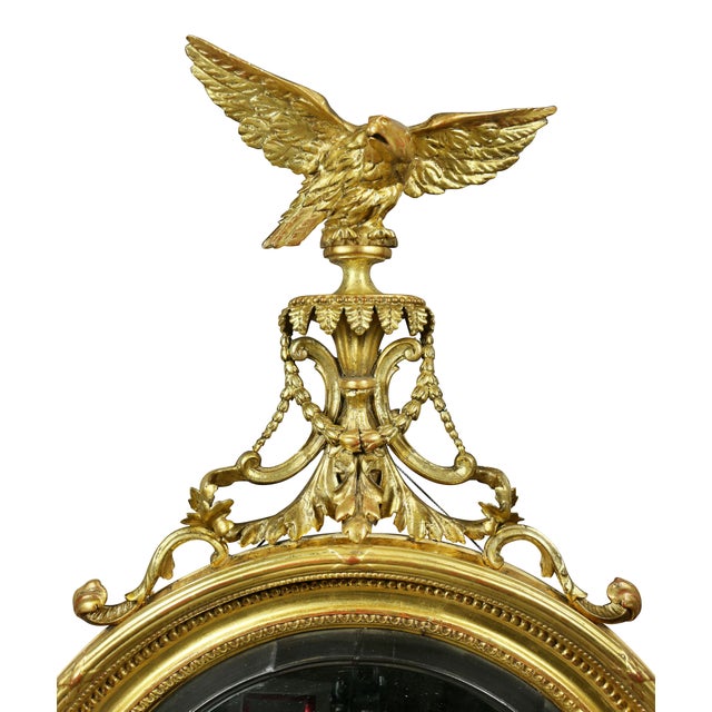 Convex mirror with eagle finial with outspread wings over bellflower and acanthus carved plinth over a circular convex...