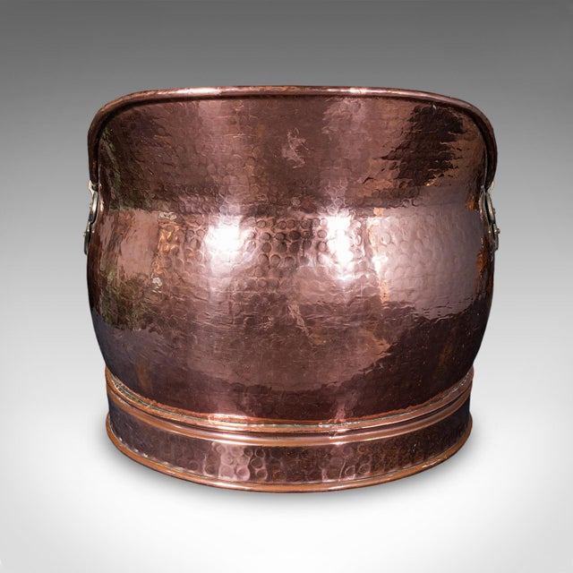 This is an antique hand finished coal scuttle. An English, copper and brass fireside store or fuel keeper, dating to the...