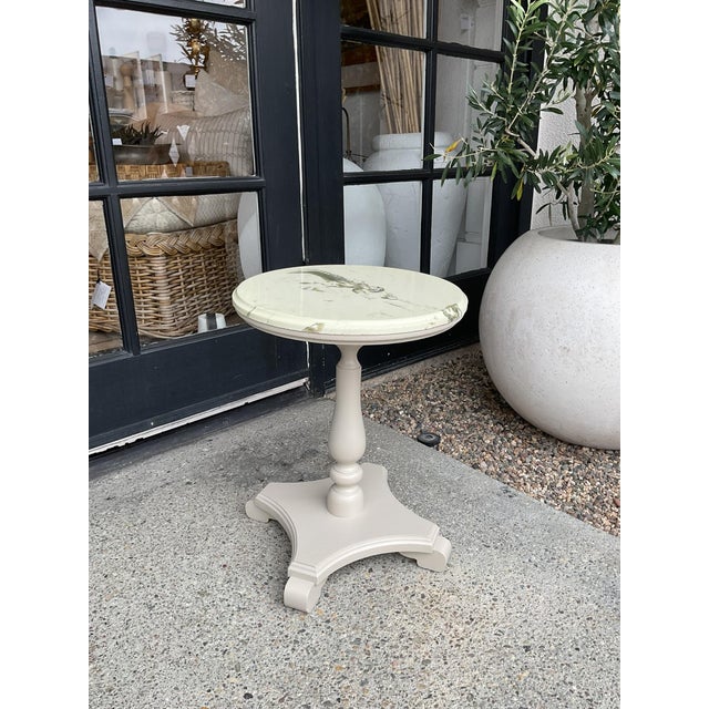 Vintage side table with a round marble top and painted pedestal base. Compact scale suitable for use as a side table,...
