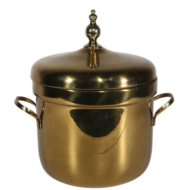 Chic Hollywood Regency style brass ice bucket by FB Rodgers. The ice bucket features a solid brass shell and top, with a...
