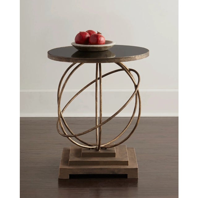 Round black granite poised over a hand painted burnished gold Saturn. Very sturdy. Top is highly stain resistant for...