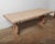 This rustic trestle dining table features a solid plank top with smoothed edges and a generously thick profile. The carved...