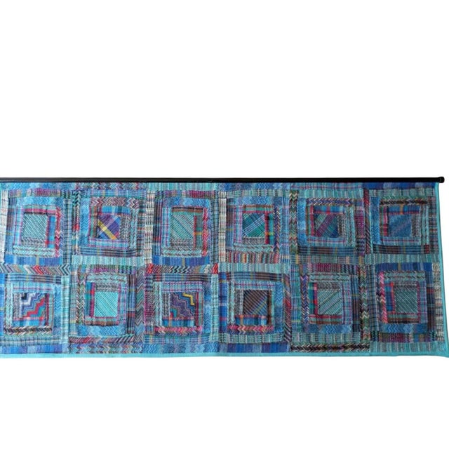 Ottavio Missoni's tapestry features his signature design. It features repeating squares in shades of blue. The textures...