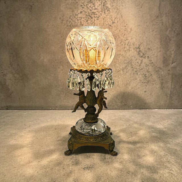 A Hollywood Regency table lamp by Loevsky & Loevsky, combining cut crystal and gilt bronze in a sculptural composition...