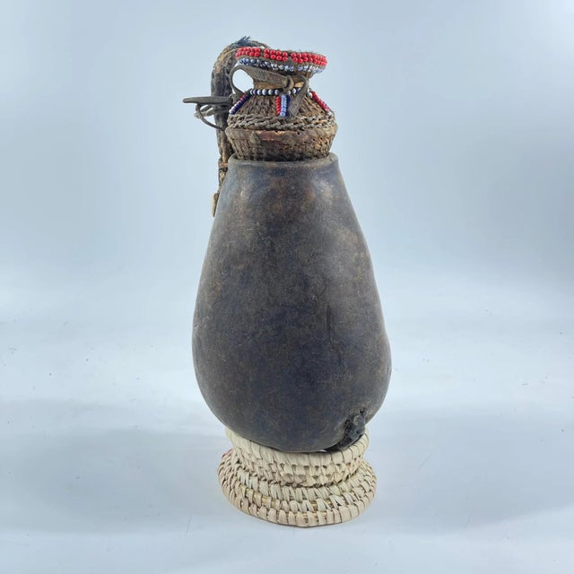 This Maasai beaded milk jug from Kenya is a meaningful example of everyday artistry within Maasai people culture....