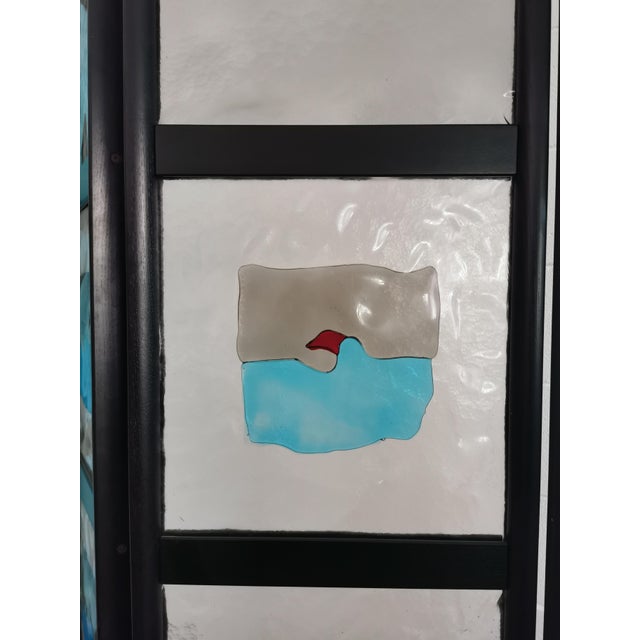 Screen with ebonized wood structure and thick internal glass in light blue and taupe, central incalmo workmanship. Made by...