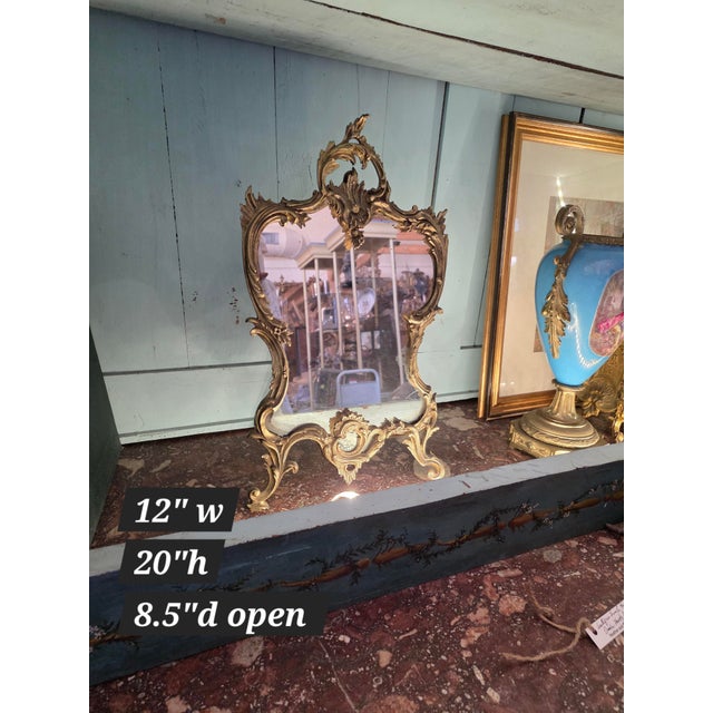 Beautiful antique rococo Gilt Brass table top mirror with easel back. The mirror glass is old but it looks re cut and not...