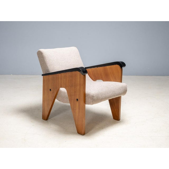 A rare mid-century lounge set consisting of three a-frame wooden armchairs and one matching coffee table, produced in...