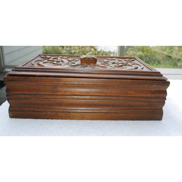 A nice antique carved walnut box that is perfect for keepsakes. It has two carved "dragons" on the lid and a flower on the...