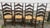 Charming set of 6 vintage ladder-back dining chairs featuring dark stained wood frames, rush woven seats, turned posts,...