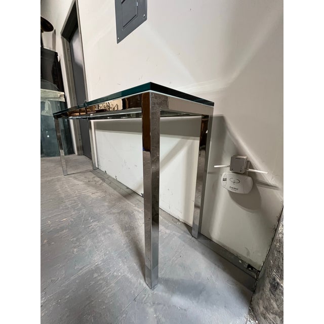 Sleek vintage Mid-Century Modern 66" long chrome and glass narrow console table. Item features a rectangular seamless...