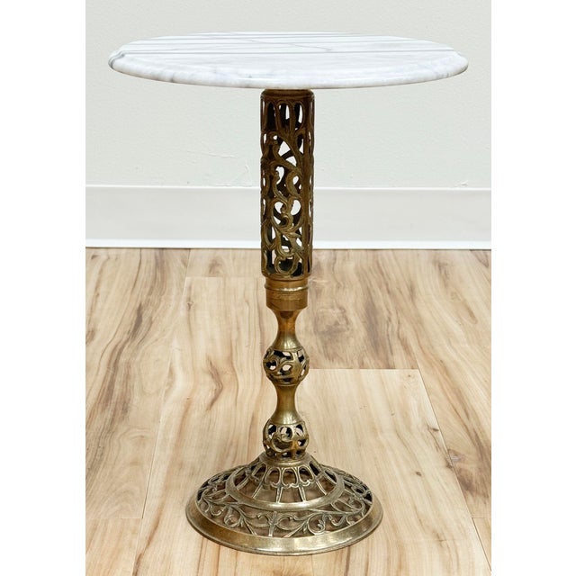 Vintage French style marble top brass filigree base side table. Round marble top features beveled edge and gorgeous...