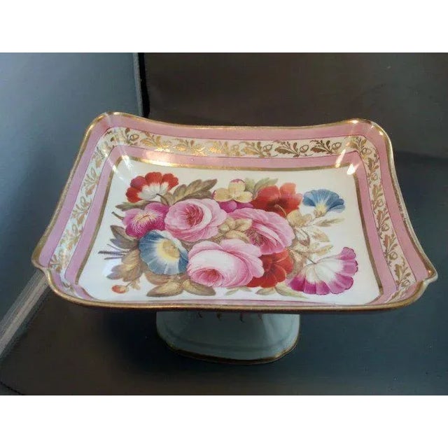An exceptional 19th century porcelain footed centerpiece decorated with a large floral reserve painting on a pink ground...