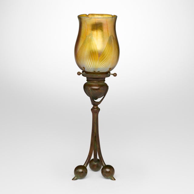This exceptional Tiffany Studios Tripod candlestick with Feather Favrile glass shade was created in the United States by...
