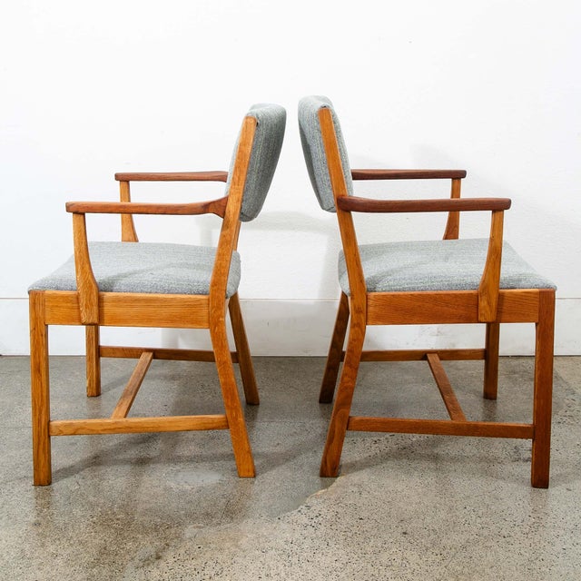 Pair of solid oak armchairs with teak armrests. Recently re-upholstered in a gray wool with green stripes. There is a...