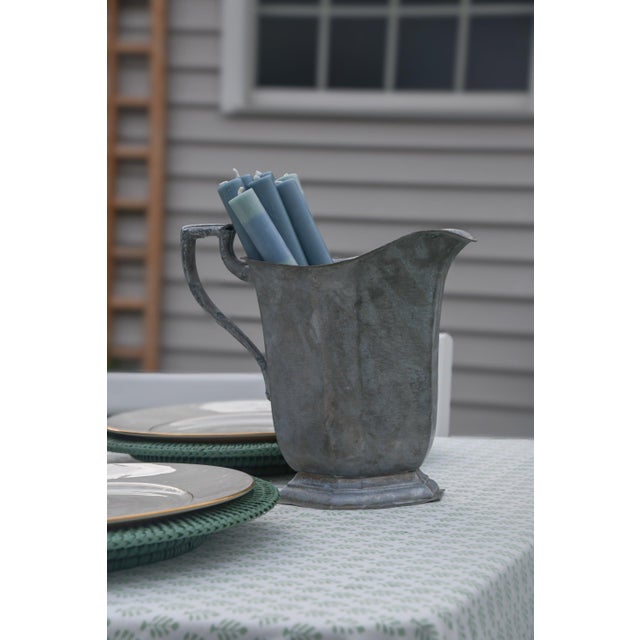 Silver plate pitcher with an angular, paneled body and hand-hammered surface, raised on an octagonal foot. Features a...