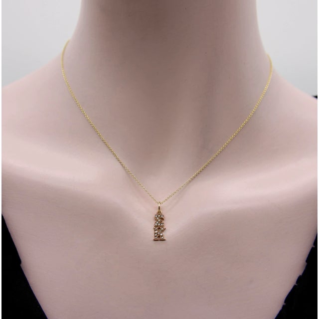This 14k gold charm features the Greek letters sigma and kappa stacked on top of each other and bead seat with seed...