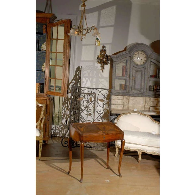 A stamped French Louis XV style small walnut slant-front desk with sliding inlaid panels, long drawer and inner...