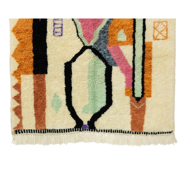 Artistic hand-knotted wool rug with abstract shapes in Desert Sun, Misty Jade, Lavender, Bluefin, Pink, Peach Caramel, and...
