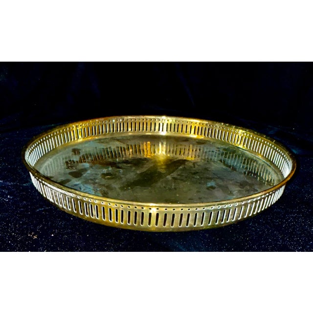 This round brass tray features a classic gallery edge, defined by its raised, slatted railing design. Its aesthetic...