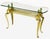 Cast and polished brass cabriole leg glass top console table. Twisted brass tube double stretcher connects brass cubes and...