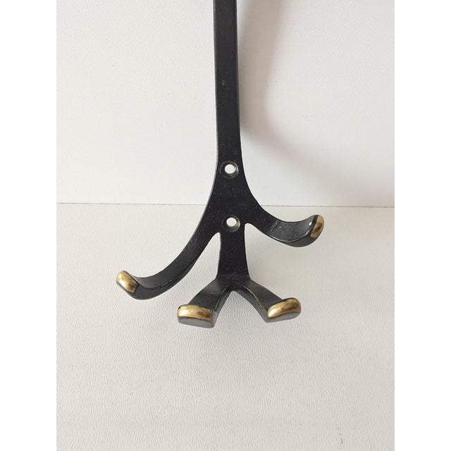 The wall hook is a design by Walter Bosse, manufactured by Herta Baller in the 1950s. The item is stamped with "Made in"...