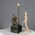 Bronze sculpture on a black marble base transformed into a table lamp. A statue of a blacksmith seated at an anvil rests...