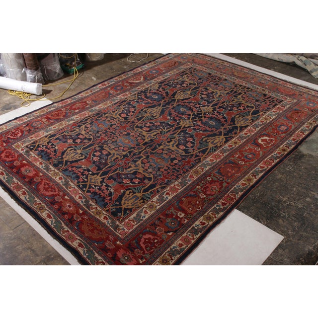 Hand knotted in wool originating circa 1900-1910, this 10x14 antique Persian rug connotes a traditional Bidjar rug design...