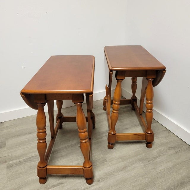 A beautifully restored pair of solid cherry drop-leaf tables by Athens Table Company of Tennessee, dated May 2, 1973. With...