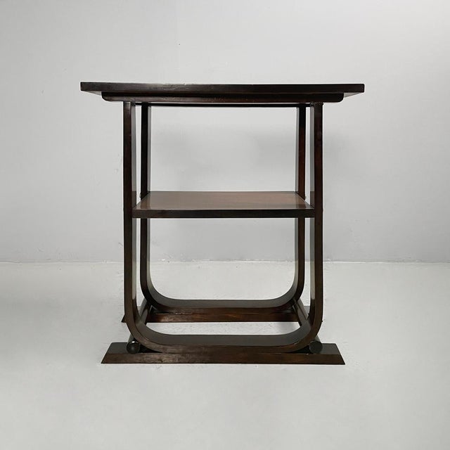 Italian Art Deco coffee table in wood, 1930s Coffee table with a dark wood structure featuring geometric yet rounded...