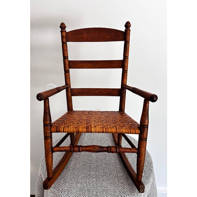 Charming vintage child’s rocking chair crafted from solid wood with a beautifully handwoven rush seat. This piece features...