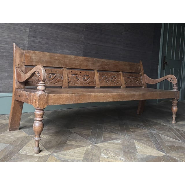 Crafted from durable teak wood, this 20th century bench likely originates from the Dutch Colonial period in Asia. Oswald...