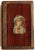 An antique French faux book box with a decoupage of a young girl on the front cover. Wood base, leatherette paper,...