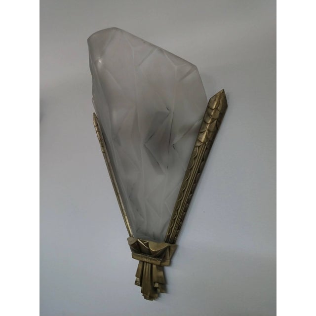 A pair of French Art Deco Wall Sconces by the French artist " Degue " in molded clear frosted glass decorated with...