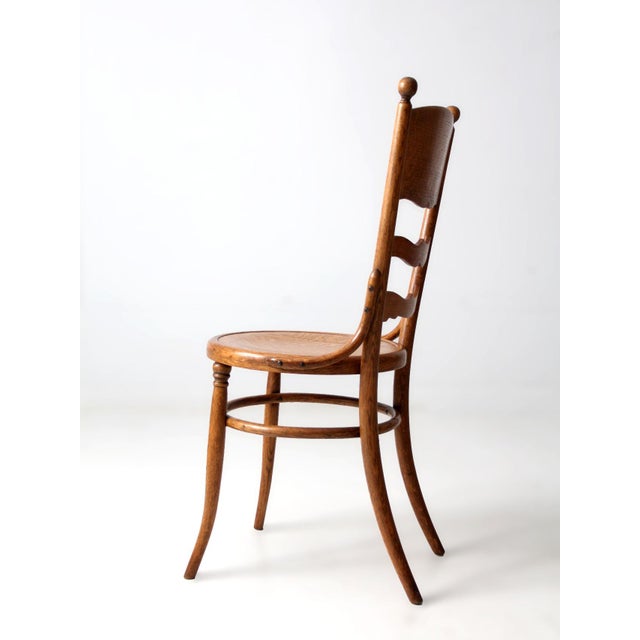 This early 20th-century Continental bentwood ladder-back side chair features clean lines, gently softened curves, and a...