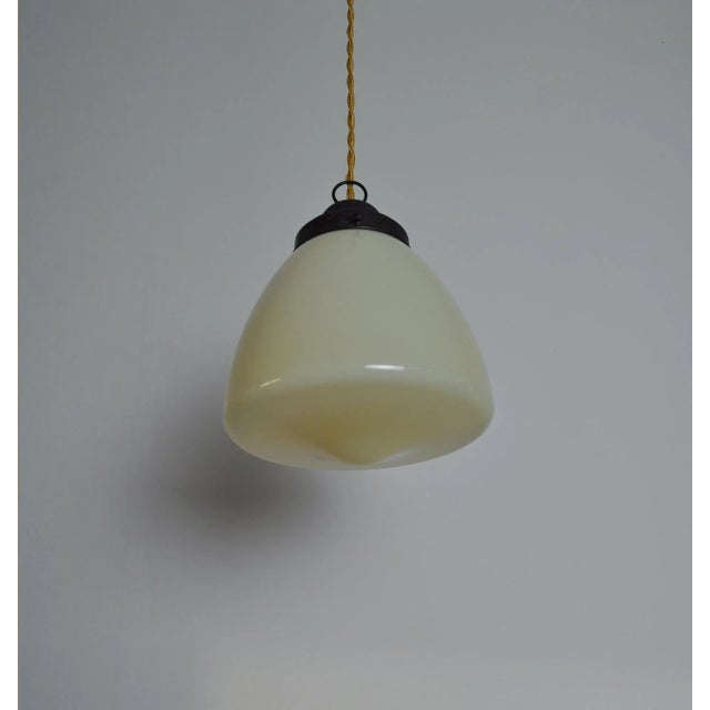 Art Deco Pendant Lamp composed of opaline glass with a brass top. The shade emits a wonderful and warm light. Rewired and...