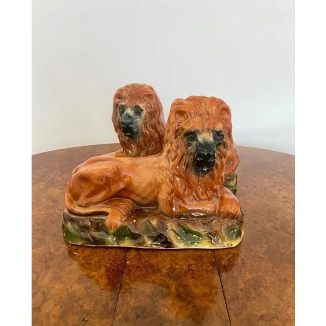 Quality pair of large antique Victorian Staffordshire lions having the original glass eyes, tan coloured coats resting on...