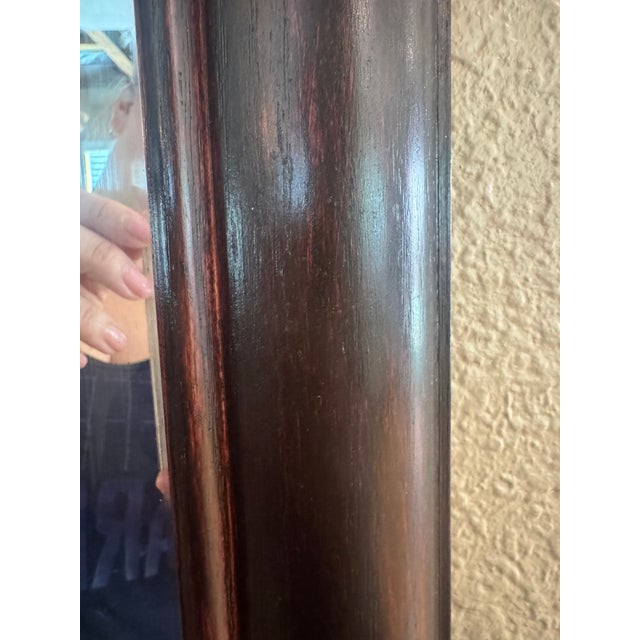 This is a large custom framed mirror meant for a large wall space with a dark cherry frame and 3 beveled mirror panels....