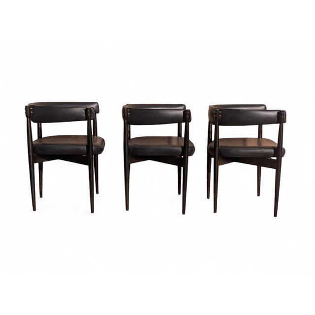 These chairs feature a design clearly inspired by Midcentury Modern, featuring a black-stained wooden frame with clean,...