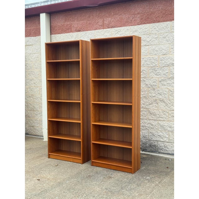 Impressive pair of vintage Mid-Century Modern bookcases with warm, richly grained wood veneers and clean architectural...
