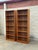 Impressive pair of vintage Mid-Century Modern bookcases with warm, richly grained wood veneers and clean architectural...