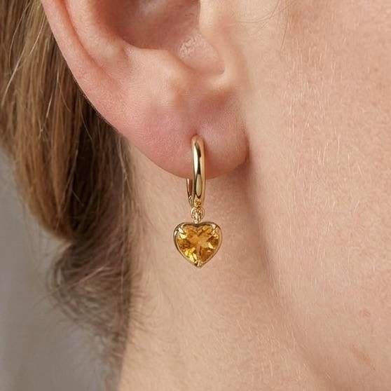 Elevate your everyday elegance with these refined drop hoop earrings, featuring vibrant golden-yellow gemstones that exude...