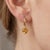 Elevate your everyday elegance with these refined drop hoop earrings, featuring vibrant golden-yellow gemstones that exude...