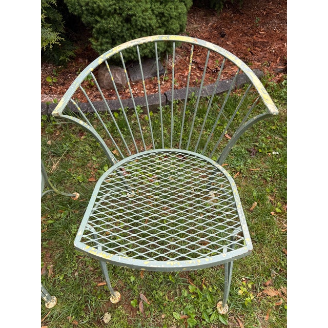A handsome set of four vintage Woodard “Pinecrest” wrought iron patio chairs, one of the most enduring and collectible...