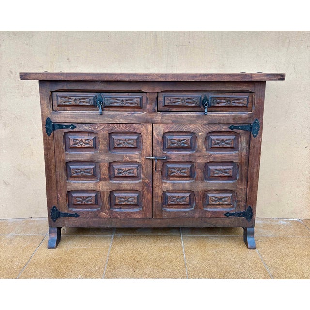 This striking Spanish rustic sideboard is crafted from solid wood and enriched with hand-carved geometric panels across...