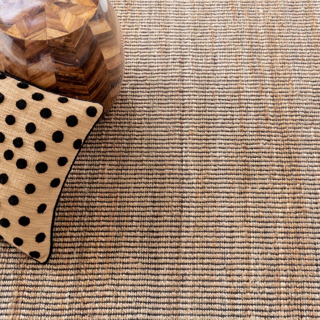 Simple weave of black cotton warp and slubby jute weft adds visual and tactile texture to this low profile flat woven rug....