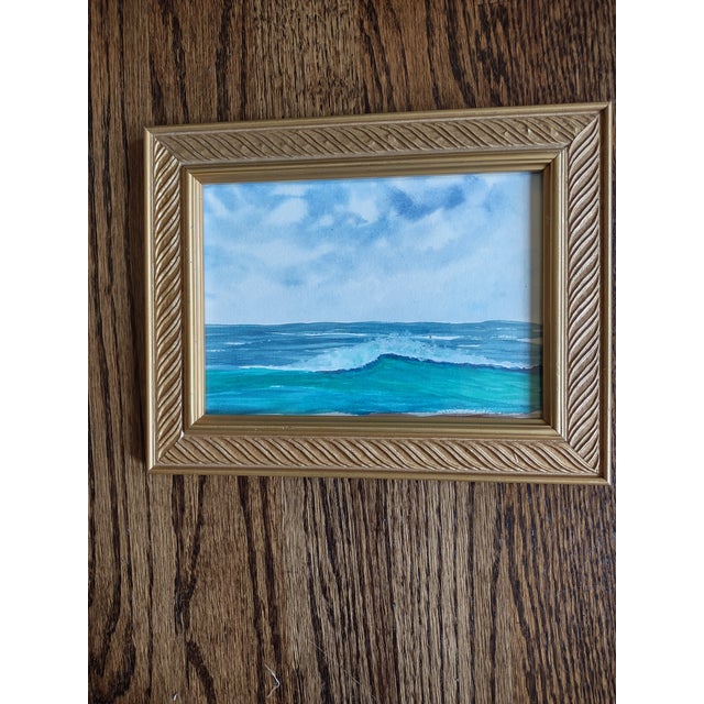 Offered is a pretty framed watercolor of an ocean view. The overall frame measures 9 by 7. It has a nice gold frame. I had...