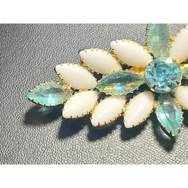 This DeLizza & Elster styled brooch combines smooth, opaque white milk glass navette cabochons with faceted aquamarine...