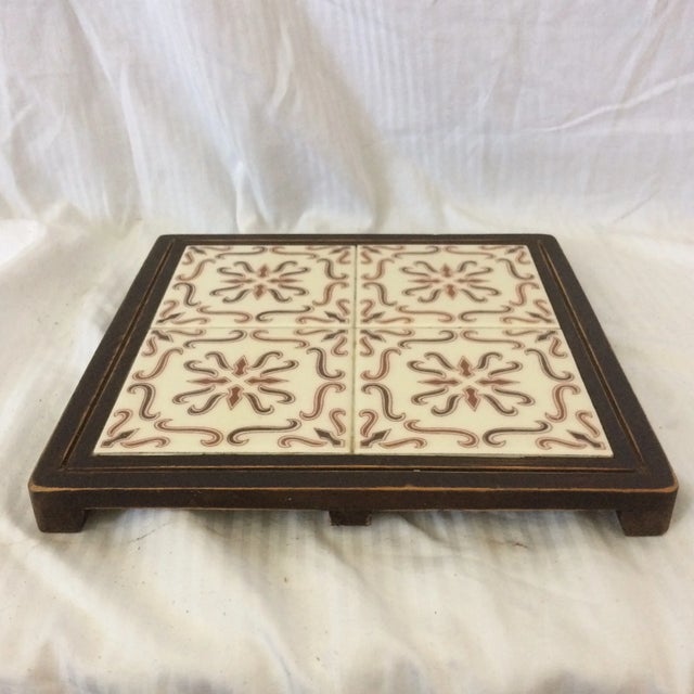 One 4 tile trivet and one single tile trivet. They are both have the same brown pattern and are set in walnut stained...